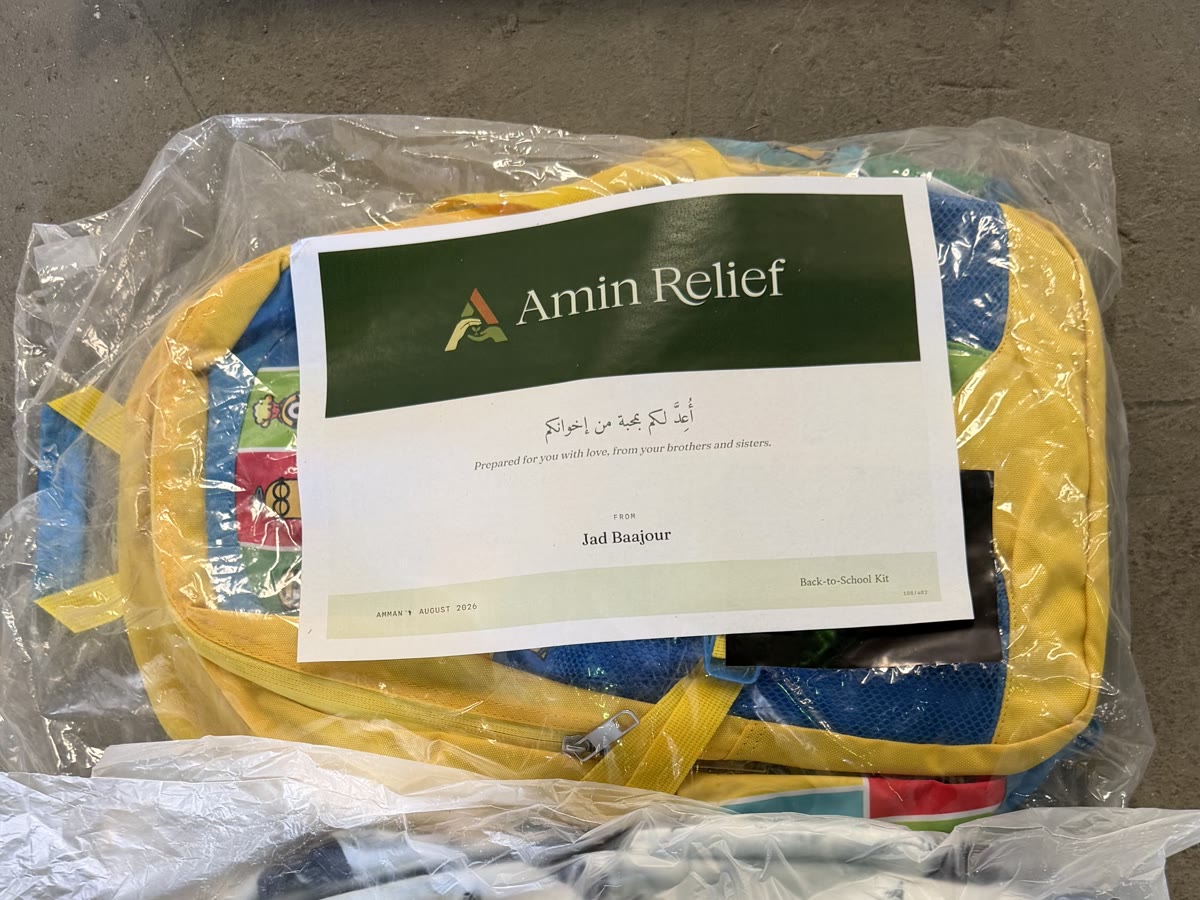 A dedication certificate resting on the bagged school kit it funded